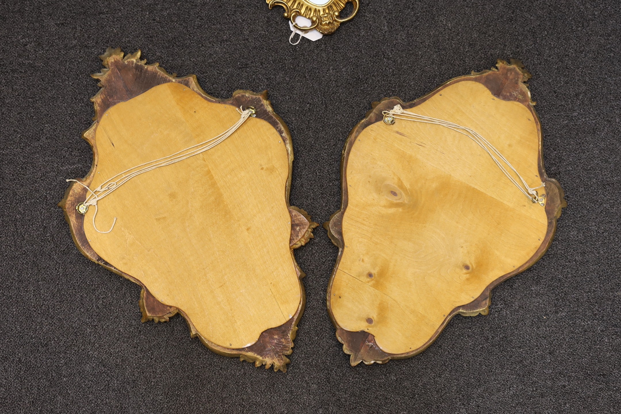 A pair of George III style giltwood cartouche wall mirrors, height 60cm, together with two similar smaller cartouche wall mirrors